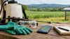A smartphone beside pesticide applicator safety gear on a farm workbench overlooking Tennessee fields