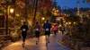Anonymous runners moving along a warmly lit theme-park path in Tennessee at night