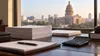 Blank budget papers and a calculator on a government finance desk with the Texas State Capitol softly blurred in the background.
