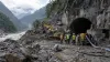 Equipos de rescate junto a la entrada de un túnel hidroeléctrico dañado por el lodo en un escarpado valle fluvial de Nepal.