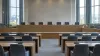 Empty international human-rights hearing room with desks and microphones before a formal session