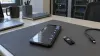 Unbranded smartphone displaying abstract settings beside a security key in a neutral equipment workspace