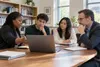 Higher-education advisers and students discussing college outcomes around a laptop in a sunlit campus office