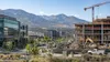 Modern offices and an active construction site beneath mountain foothills in Utah