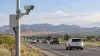 Unbranded roadside camera beside traffic in a high-desert mountain valley