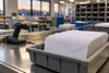 Sealed ballot envelopes in a postal sorting tray under neutral indoor light