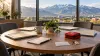 Round coordination table with folders, a house key and first-aid kit overlooking Utah mountain foothills