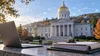 Editorial illustration of the Vermont State House with a laptop, policy documents and a subtle digital network motif.
