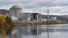 Conceptual editorial image of a decommissioned industrial energy facility beside a river in Vermont.