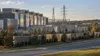 A large data center campus, electrical substation and transmission lines stand near a Virginia residential area.
