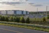 Large data center campus, electrical substation and nearby homes viewed from a Virginia roadside