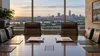 An empty Omaha boardroom with two executive chairs, financial documents and a freight train visible beyond the windows.