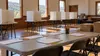 Empty community polling place prepared with privacy booths, blank sign-in sheets, pencils and sealed supply boxes