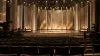 An empty television awards stage with golden lighting and camera equipment