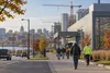 Anonymous workers near construction cranes and an industrial facility in Wisconsin during early autumn.