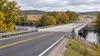 Illustrative view of a rural Wisconsin road approaching a concrete bridge amid early autumn farmland.