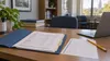 A university admissions folder and blank answer sheet rest on a desk in a quiet office.