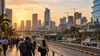 Commuters and public transit move through a growing African business district at sunrise.