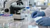 AI-generated illustrative scene of gloved laboratory hands preparing a tissue slide beside a microscope.