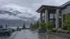 Illustrative view of a quiet civic building in Juneau under low clouds and coastal fog.