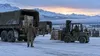 Illustrative view of winter military logistics crews moving supplies at an Alaskan base