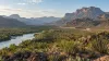Vista representativa do Rio Grande a serpentear pelo terreno desértico do oeste do Texas, junto a uma barreira rodoviária ao longe