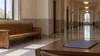 AI-generated editorial image of a quiet, generic courthouse corridor with an unmarked folder on a table.