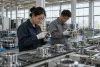 AI-generated illustrative photograph of a generic industrial production floor with workers inspecting unbranded metal components