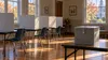 Illustrative Connecticut municipal voting room with privacy booths and a sealed ballot box