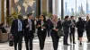 International finance delegates confer inside a modern conference venue in Bangkok.