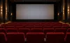 AI-generated illustrative view of an unbranded cinema auditorium with red seats and a blank screen