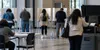 Voters use privacy booths and a ballot scanner inside a neutral community polling place.