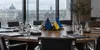 An empty diplomatic conference table with European Union and Ukrainian desk flags after a policy meeting.