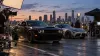 Two unbranded performance cars on a controlled film set at dusk with cameras and crew nearby.