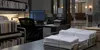 Stacks of sealed court notices beside a secure workstation in a quiet federal courthouse records office.