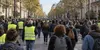 AI-generated illustrative scene of a peaceful crowd, including people wearing yellow vests, walking along a French city avenue.
