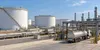 Illustrative view of fuel storage tanks, refinery piping and an unbranded tanker truck at a petroleum terminal.
