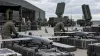 Vista ilustrativa de drones intercetores e equipamento de defesa aérea numa instalação logística militar europeia