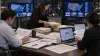 Political campaign media planners review advertising budgets and television market maps.