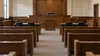 AI-generated illustration of an empty generic courtroom with wooden benches; not a photograph of Shirts’s swearing-in or an Idaho court.