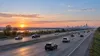 Imagem ilustrativa do trânsito matinal numa autoestrada interestadual de Illinois, com veículos de passageiros e carrinhas de caixa aberta sem identificação da marca.