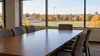 AI-generated illustration of an empty generic university athletics meeting room overlooking an unbranded sports field in Kansas; not a photograph of a specific campus or board meeting.