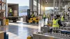 Illustrative view of anonymous workers in a modern light-industrial and logistics workplace.