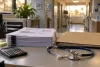 A stethoscope, calculator and stack of redacted billing forms sit on a desk in a generic medical office.
