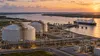 Illustrative view of a generic LNG export terminal beside a broad Louisiana river channel.