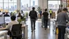 Anonymous workers move through a modern Massachusetts workplace in an editorial illustration of the state labor market.