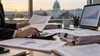 An analyst reviews campaign finance records and charts with the U.S. Capitol in the background.