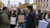 Illustrative image of a diverse group at a peaceful autumn civic rally beside a voter information table