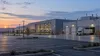 Illustrative view of a modern heavy-truck assembly plant in Ohio at dawn with an empty parking area.