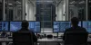 AI-generated illustrative view of two security engineers monitoring an isolated server rack in a modern data-center operations room.